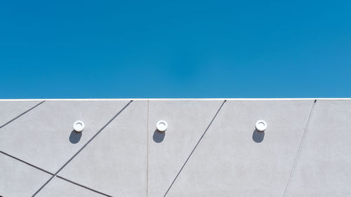 Low angle view of white wall against blue sky