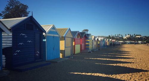 Beach huts against clear blue sky