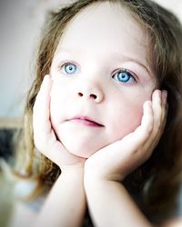 Close-up of cute girl with blue eyes looking away