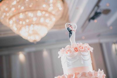 Close-up of illuminated candle with wedding cake