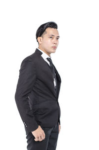 Young man standing against white background