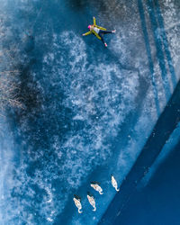 High angle view of woman lying on frozen lake