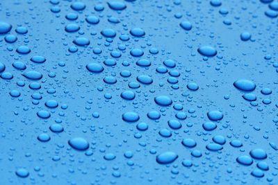 Full frame shot of raindrops on blue surface