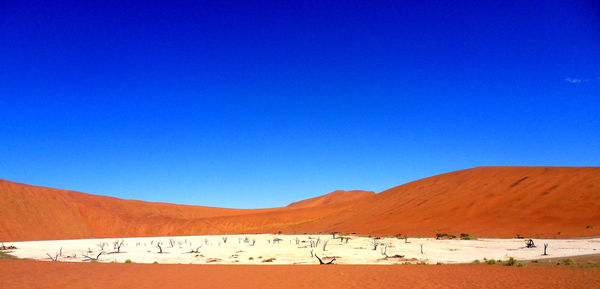 Scenic view of desert against clear blue sky