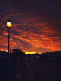 Street lights against orange sky