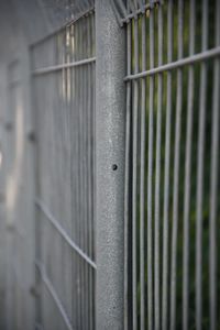 Close-up of metal fence against wall