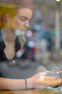 Young woman in cafe using smart phone