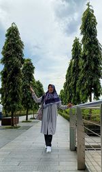 Rear view of woman standing against trees