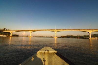 Bridge over river against sky during sunset