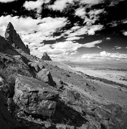 Scenic view of shiprock against cloudy sky