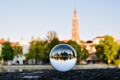 Close-up of crystal ball on building against clear sky