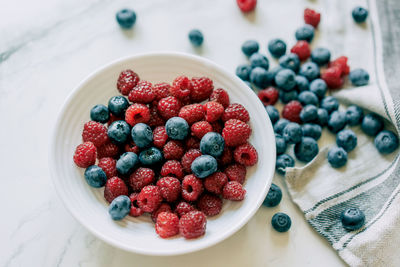 Top view of pile of fresh and healthy and berries for wellness on marble background.