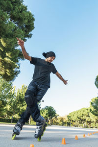 Low angle view of young man jumping against sky