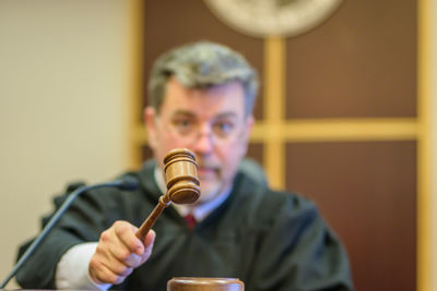 Close-up of judge banging gavel in courtroom