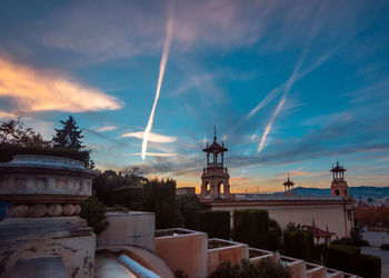 Buildings in city against sky during sunset