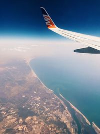 Aerial view of airplane flying over blue sky