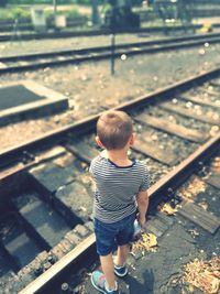 Rear view of boy on railroad track