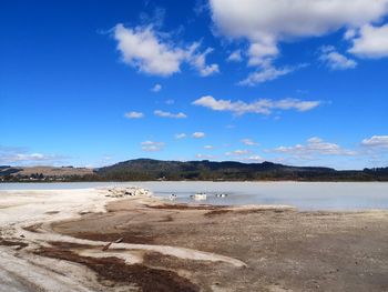 Scenic view of beach against blue sky