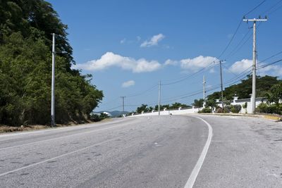 Road amidst trees against sky