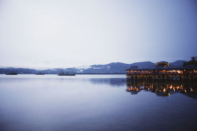 Scenic view of lake by buildings against sky