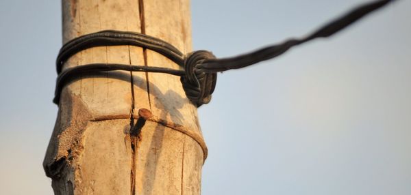 Low angle view of wooden post against clear sky