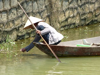 Man working on fishing net in lake