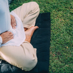 Male therapist performing reiki therapy self treatment holding hands over his stomach. 