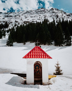 House on snow covered mountain against sky