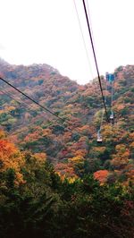 Overhead cable car over mountains against sky