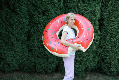 Midsection of woman holding donut on field