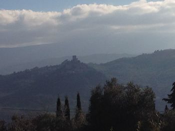 Scenic view of mountains against cloudy sky