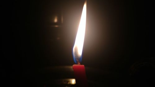 Lit candle in dark room