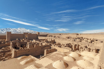 Text on sand dune in desert against blue sky