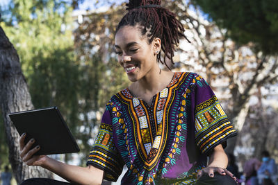 Midsection of woman holding smart phone outdoors