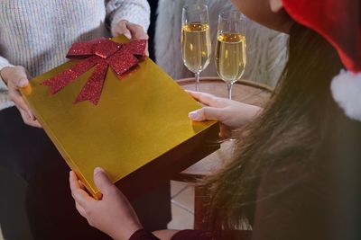 Midsection of man and woman holding gift during christmas