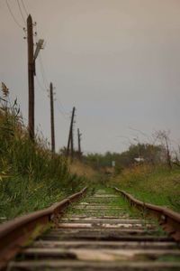 Railroad track amidst grass against sky