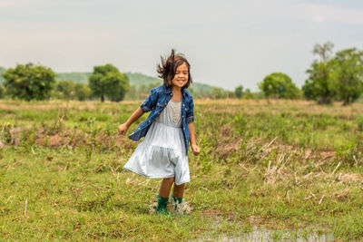 Full length of a smiling girl on field