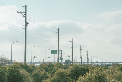 Low angle view of electricity pylons against sky