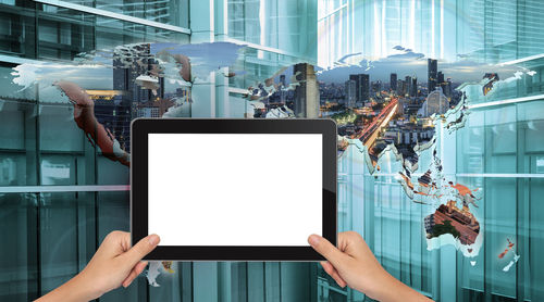 Cropped hands of woman holding digital tablet against digitally composite world map