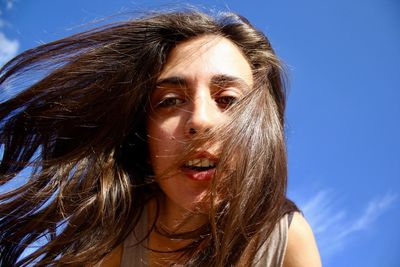 Close-up portrait of woman against sky