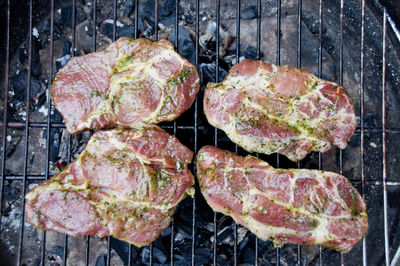 Directly above shot of pork cooking on barbecue grill