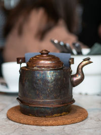 Antique copper teapot on the table served for breakfast. front view. lifestyle
