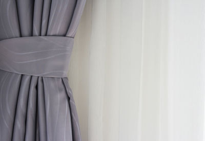 Close-up of white curtain hanging against wall