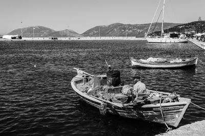 Boats moored in sea against clear sky