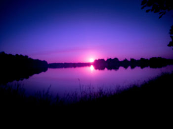 Scenic view of lake against sky at sunset