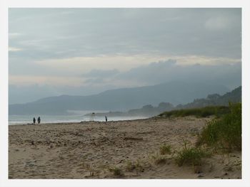 Scenic view of mountains against cloudy sky