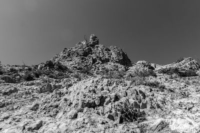 Low angle view of rocks against clear sky