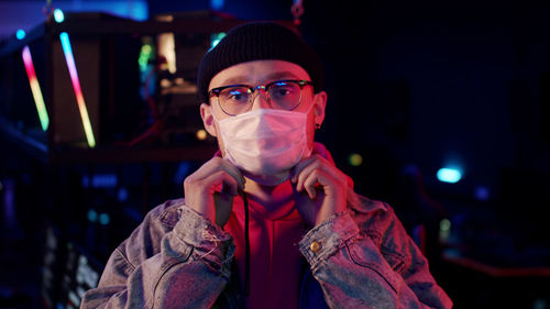 Portrait of man wearing mask standing outdoors at night