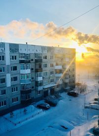 Buildings in city against sky during sunset