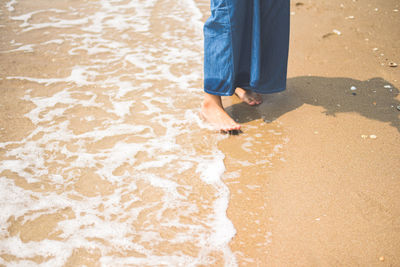 Low section of woman standing on beach